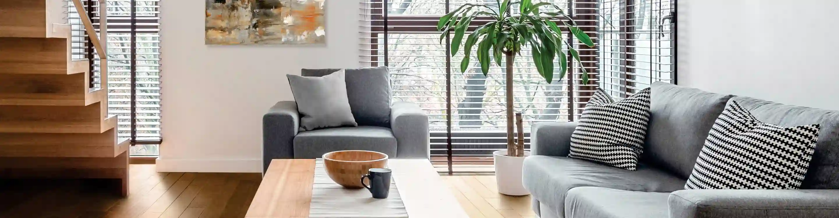 wood look blinds in living area with gray furniture and light hardwood flooring